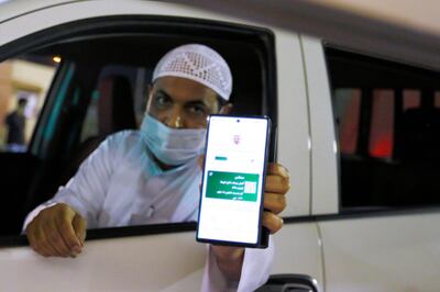 A Saudi national shows his vaccination certificate on his smart phone at Bahraini Immigration check-post as he enters Bahrain, after Saudi authorities lift the travel ban on its citizens after fourteen months due to Coronavirus (COVID-19) restrictions, at King Fahad Causeway, Bahrain, May 17, 2021. REUTERS/Hamad I Mohammed