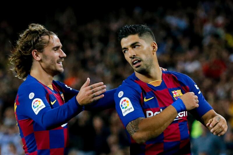 Barcelona's Uruguayan forward Luis Suarez is congratulated by teammate Antoine Griezmann after scoring the first of his two second-half goals against Valencia. AFP