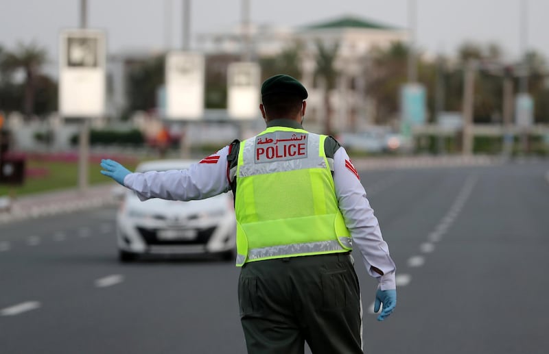 DUBAI, UNITED ARAB EMIRATES , April 16– 2020 :- Dubai Police officer stopping the private vehicles and checking the movement permit near Madinat Jumeirah in Dubai. Dubai is conducting 24 hours sterilisation programme across all areas and communities in the Emirate and told residents to stay at home. UAE government told residents to wear face mask and gloves all the times outside the home whether they are showing symptoms of Covid-19 or not.  (Pawan Singh / The National) For News/Online/Instagram