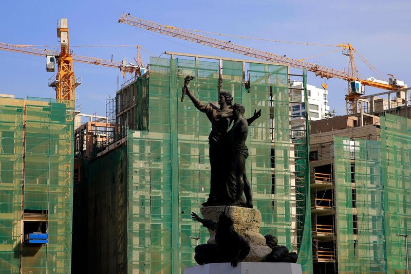In this Monday, April 2, 2018 photo, the iconic Martyrs' Monument, that was created by the Italian artist Marino Mazzacurati, stands in front of apartment buildings that are under construction, in downtown Beirut, Lebanon. Some 50 countries and international organizations are expected at the CEDRE (Cedar) conference that begins Friday, in Paris, where Beirut will request up to $22 billion for an eight to 12 year investment program as it grapples with low growth and soaring debt. (AP Photo/Hassan Ammar)