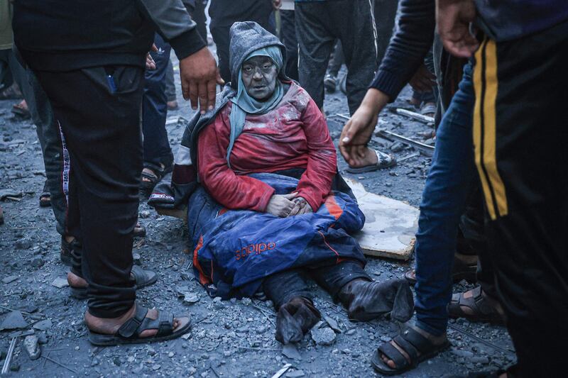 A woman injured in an Israeli strike sits amid the rubble in Rafah. AFP