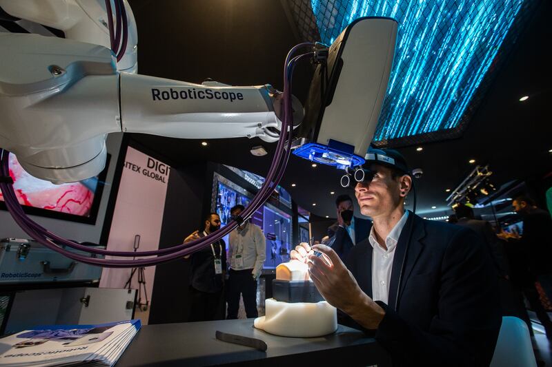 A visitor uses a robot microscope at BHS Technologies' stand.