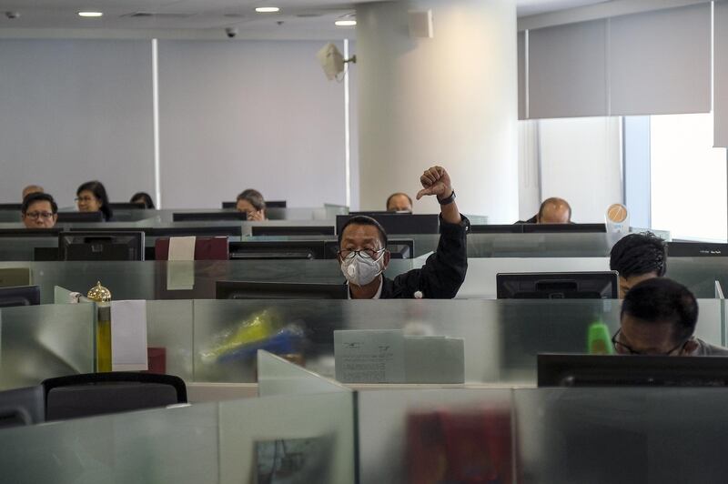 A trader wearing a protective mask gives a thumb down on the trading floor of the Philippine Stock Exchange in Metro Manila, the Philippines. Bloomberg
