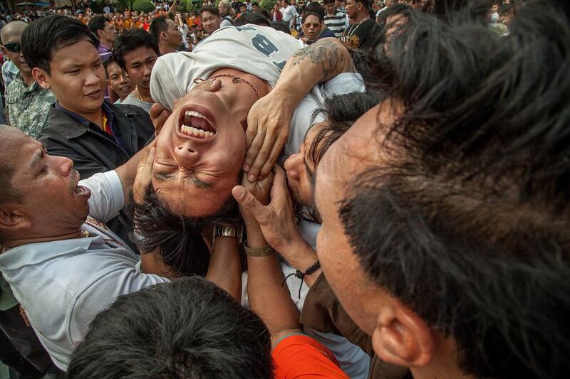 A Thai devotee in state of trance is helped by volunteers during the celebration of the annual Tattoo festival at Wat Bang Phra Thailand. Omar Havana / Getty 