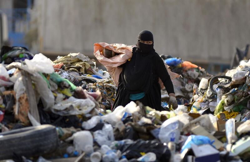 A woman collects recyclable items at a landfill site in the Iraqi holy city of Najaf. AFP