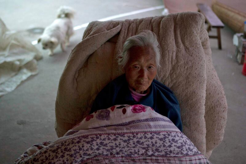 An elderly woman rests on a makeshift bed setup outdoors near Shangli town in southwestern China's  Sichuan province, Sunday, April 21, 2013. Residents awoke Sunday after spending the night outdoors or in their cars in a town near the epicenter of a powerful earthquake that struck the steep hills of China's southwestern Sichuan province, leaving at least 160 people dead and more than 6,700 injured. (AP Photo/Ng Han Guan) *** Local Caption ***  China Earthquake.JPEG-0d89d.jpg