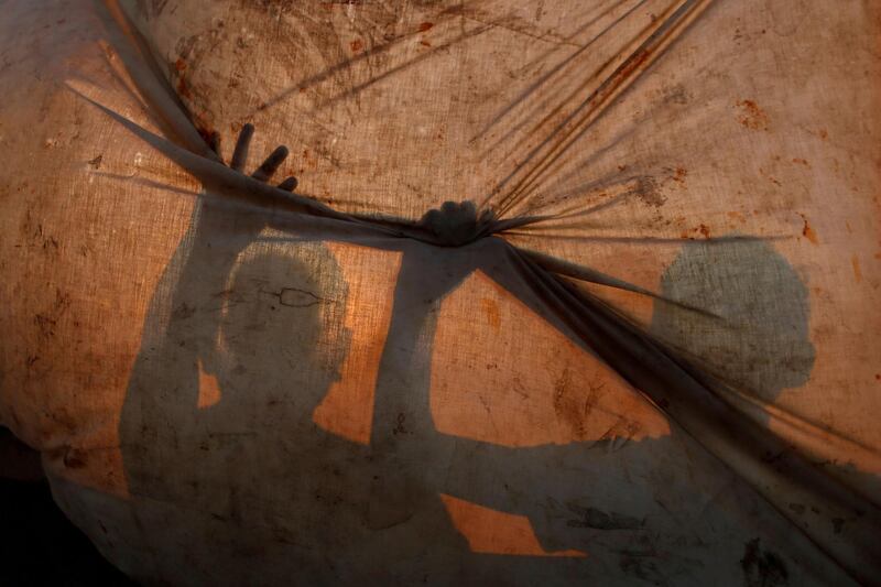 Palestinian fishermen repair their net at Al Shati refugee camp in Gaza City. Reuters