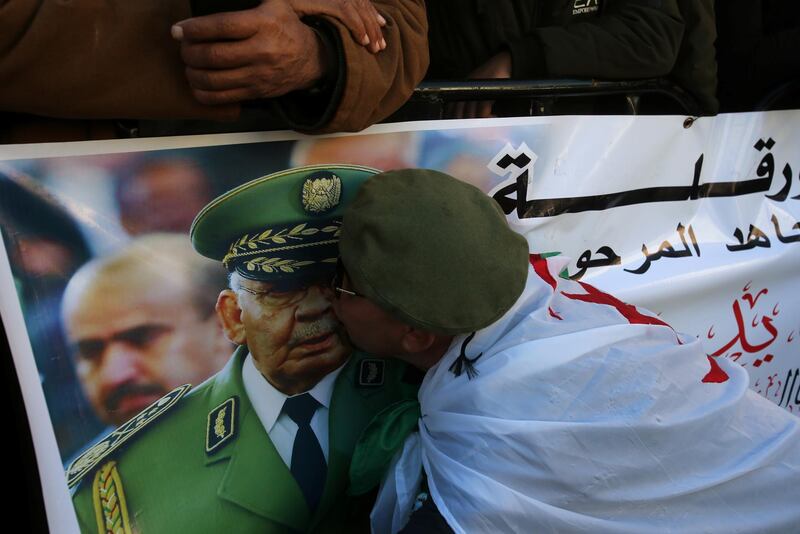 A participant kisses a picture of Lt Gen Gaid Salah. Reuters