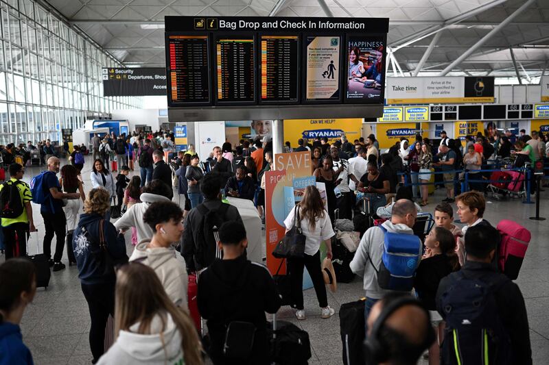 Passengers check the boards at Stansted Airport, north of London. AFP