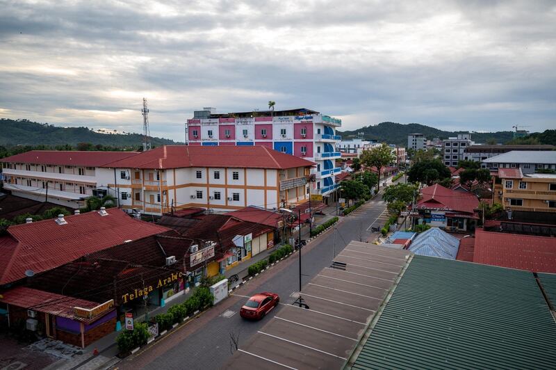 A car drives past closed shops and hotels at the formerly popular tourist destination of Pantai Cenang on the holiday island of Langkawi, which has been recently closed to most outside visitors due to a partial lockdown set by authorities to curb the spread of the Covid-19 coronavirus, on the northern Malaysian state of Kedah on November 18, 2020. (Photo by Mohd RASFAN / AFP)