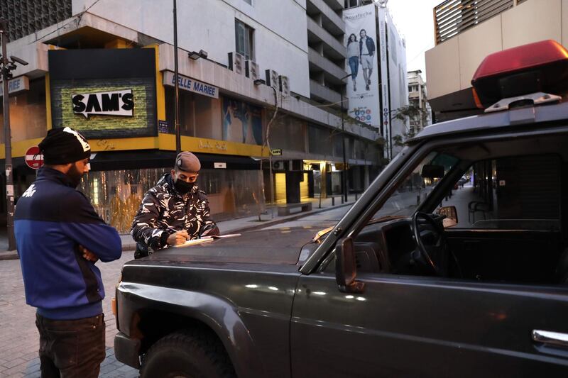 A Lebanese policeman fines a man for violating lockdown rules in Beirut's Hamra street. AFP