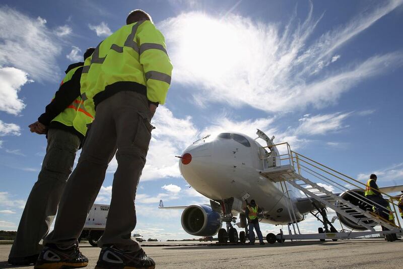 Employees look at the CSeries aircraft after its first test flight in Mirabel, Quebec in 2013. Christinne Muschi / Reuters
