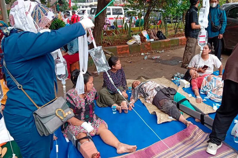 People injured during the earthquake receive treatment at a hospital car park in Cianjur. AP