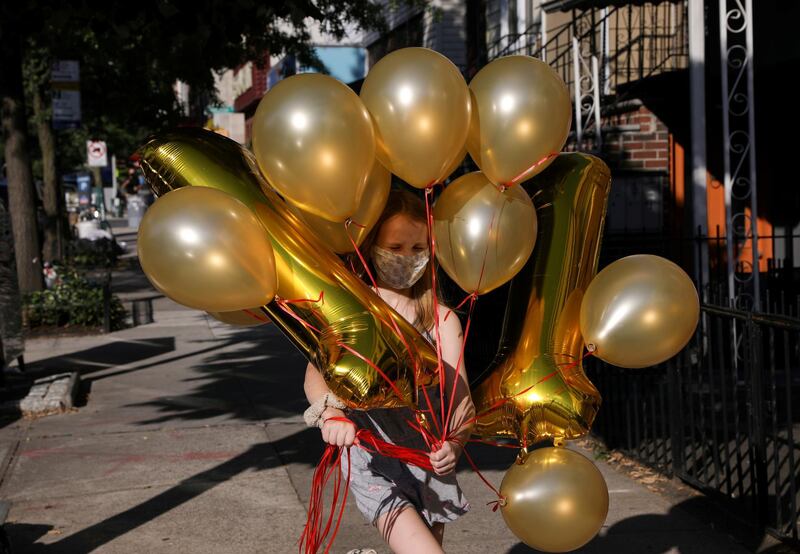 Lydia Hassebroek carries balloons for her birthday party in Brooklyn as New York slowly reopens during the continued outbreak of the coronavirus disease in Brooklyn, New York. Reuters