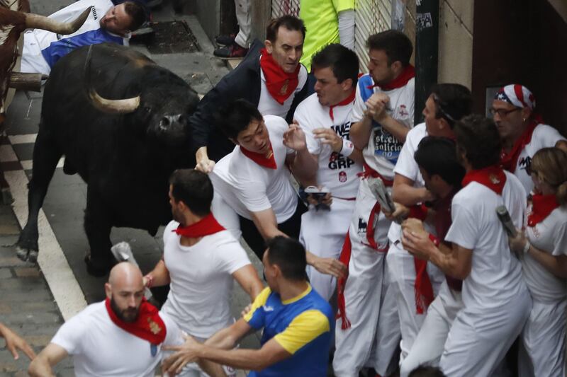 Runners known as "Mozos" sprint along the 850-metre cobbled-street course trying to escape the wrath of the bull.  Javier Lizon / EPA