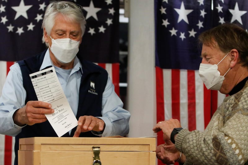 Selectman Les Otten drops a ballot in a box shortly after midnight for the US presidential election at the Hale House at Balsams Hotel in the hamlet of Dixville Notch. Reuters