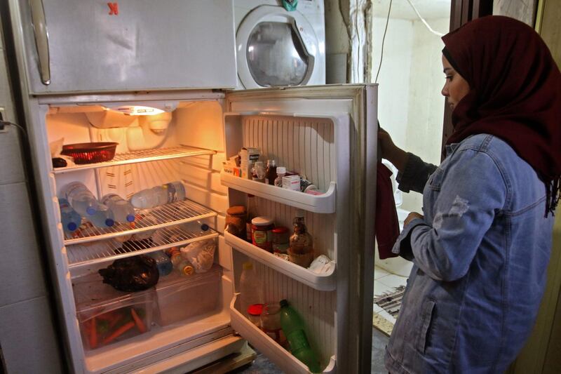 A Lebanese woman displays the content of her refrigerator at her apartment in the southern city of Sidon. AFP