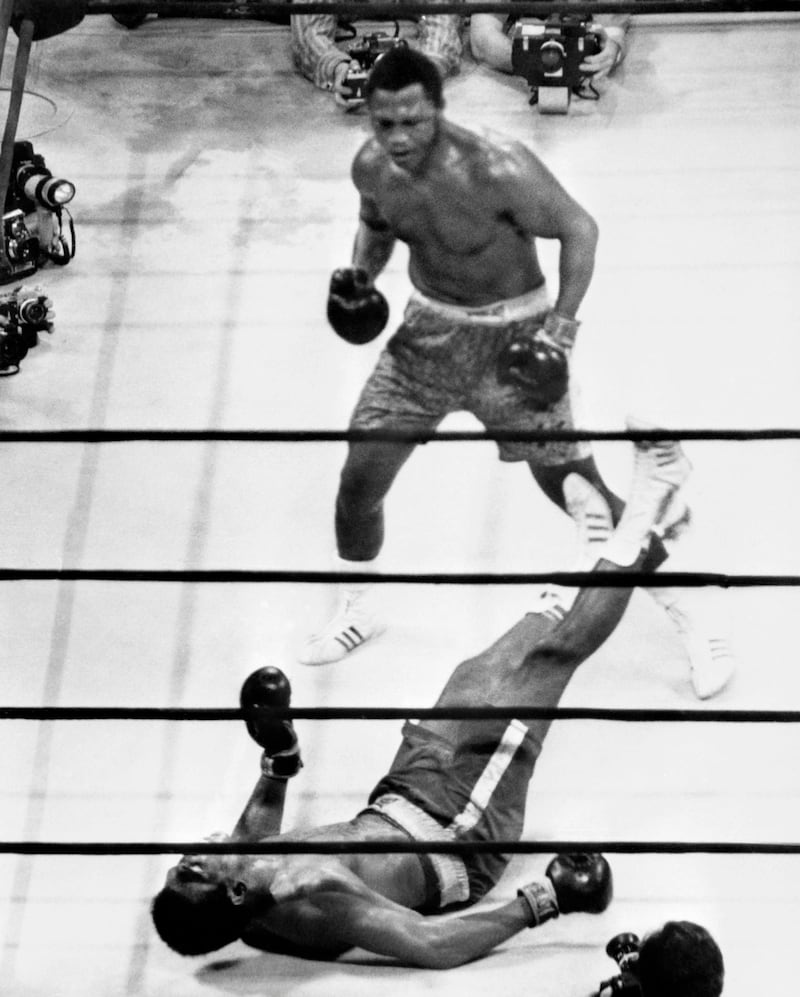 Joe Frazier stands over Muhammad Ali as he wins their 1971 fight. AFP