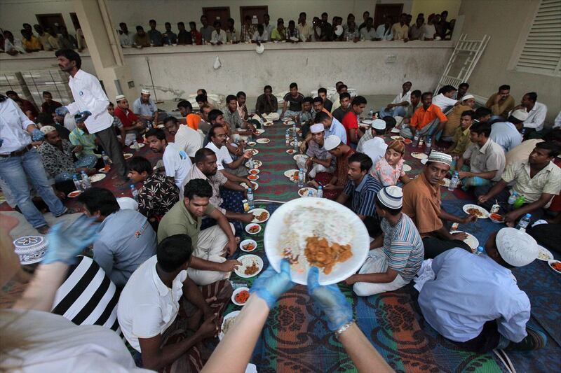 United Arab Emirates - Dubai - Aug 14 - 2010 : Volunteers pass a meal for labourers workers during Ramadan in a labour camp in Al Quoz 2. ( Jaime Puebla / The National ) Magazine