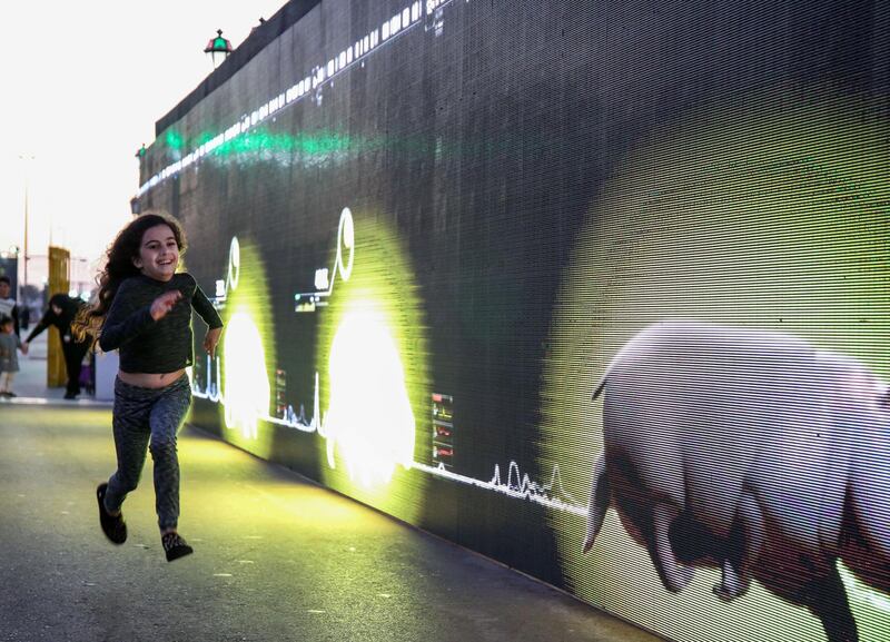 Abu Dhabi, United Arab Emirates, December 31, 2017.   New Year's Eve At the Abu Dhabi New Year's Eve Village.  A little girl races agains a Digital Hippopotamus at the Running Wall.
Victor Besa for The National.
National
Reporter:  John Dennehy