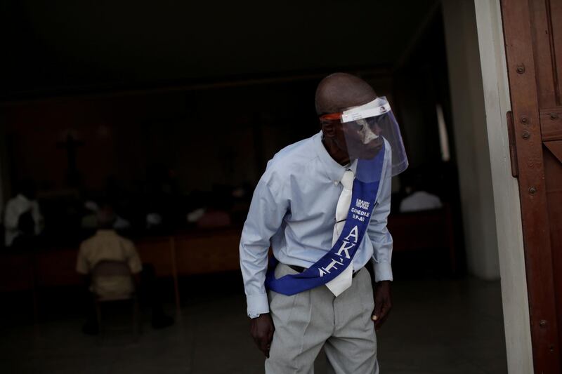 A parishioner, using a face shield, looks on at an entrance of the cathedral during a mass on the first day of the reopening of places of worship amid the coronavirus outbreak, in Port-au-Prince, Haiti. Reuters