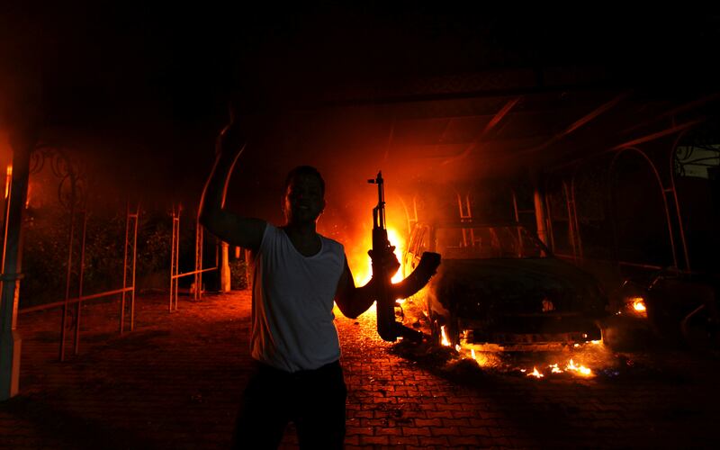 FILE PHOTO: A protester reacts as the U.S. Consulate in Benghazi is seen in flames during a protest by an armed group said to have been protesting a film being produced in the United States September 11, 2012. REUTERS/Esam Al-Fetori/File Photo