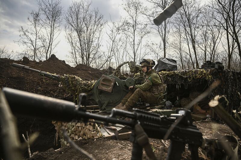 A Ukrainian serviceman sits on an anti-air gun near Bakhmut. AFP