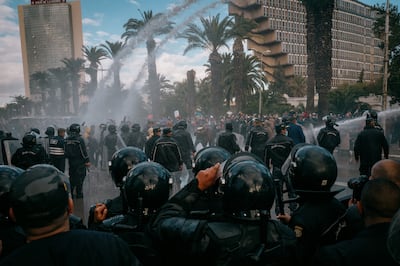 Protestors hold off armed police forces brandishing water cannons in Tunis, Tunisia.