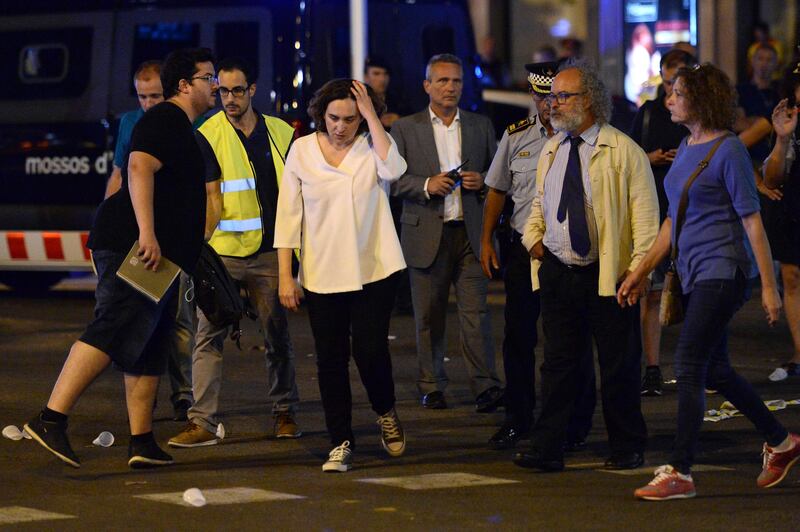 TOPSHOT - Barcelona's Mayor Ada Colau (3rdL) and officials arrive on the Rambla boulevard after a van ploughed into the crowd, killing at least 13 people and injuring around 100 others on the Rambla in Barcelona on August 17, 2017.
A driver deliberately rammed a van into a crowd on Barcelona's most popular street on August 17, 2017 killing at least 13 people before fleeing to a nearby bar, police said. 
Officers in Spain's second-largest city said the ramming on Las Ramblas was a "terrorist attack". The driver of a van that mowed into a packed street in Barcelona is still on the run, Spanish police said. / AFP PHOTO / Josep LAGO