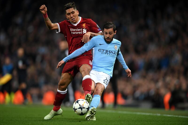 Liverpool's Roberto Firmino of Liverpool battles for posession with Manchester City's Bernardo Silva. Shaun Botterill / Getty Images