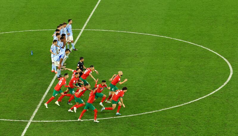 Morocco's players celebrate their penalty shootout win as the losing Spanish player look on. Reuters