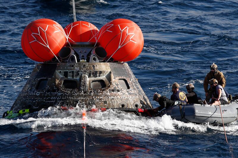 US Navy divers attach winch cables to Nasa's Orion capsule off the coast of Baja California, Mexico. EPA