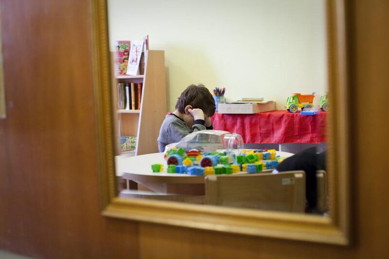 Hasan Limo, 7, who has autism, tries to drown out noise in a room at the Donje Rosulje Kindergarten School, where teachers are trained to help integrate children with disabilities into mainstream classes. Razan Alzayani / The National