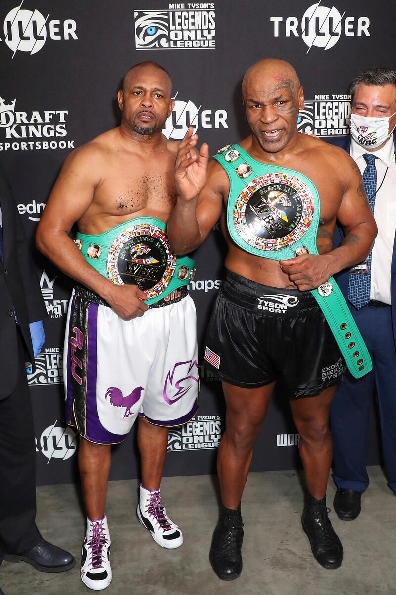 Roy Jones Jr., left, and Mike Tyson pose for photos after their exhibition boxing bout in Los Angeles. The bout was unofficially ruled a draw by the WBC judges at ringside. Triller via AP