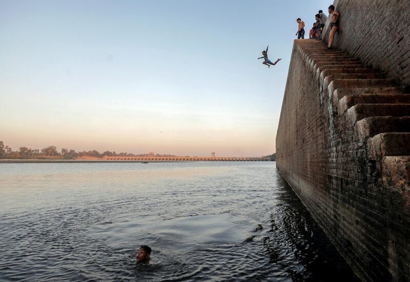 A boy jumps in the Nile River during hot weather on the outskirts of Cairo, following the outbreak of the coronavirus disease (COVID-19), Egypt August 18, 2020. REUTERS/Mohamed Abd El Ghany     TPX IMAGES OF THE DAY