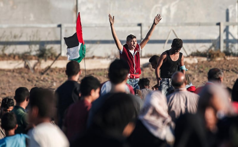 A young protester chants as others wave Palestinian flags during a demonstration at the border fence with Israel, east of Gaza city. AFP