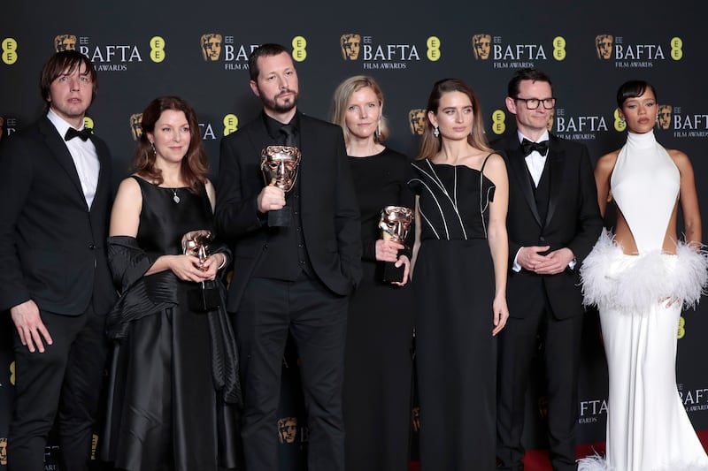 Raney Aronson-Rath, second left, Mstyslav Chernov, third left, Michelle Mizner, centre, and Taylor Russell, right, pose with the Best Documentary awards for '20 Days in Mariupol'. Getty Images