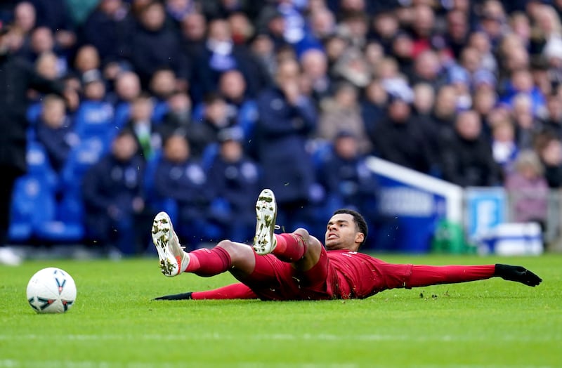 Liverpool's Cody Gakpo lies on the pitch after being challenged by Lewis Dunk. PA