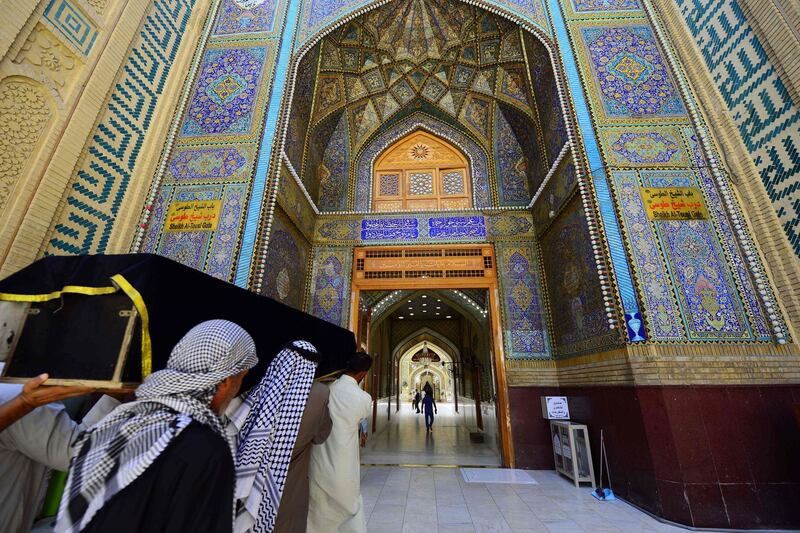 Shiite Muslim men carry a coffin to the Imam Ali Ibn Abi Talib mosque in Iraq's central shrine city of Najaf during a funeral procession, one of the very rare ceremonies still allowed in the city during the coronavirus pandemic. AFP