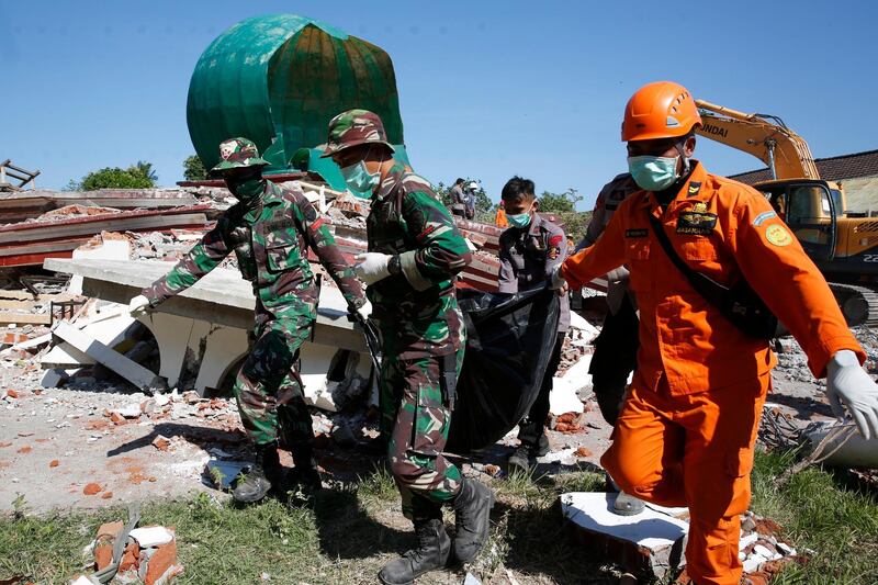 Indonesian rescuers and soldiers carry a victim in a body bag from a collapsed mosque after an earthquake struck northern Lombok, West Nusa Tenggara, Indonesia. According to media reports, a 7.0 magnitude quake hit Indonesia's island of Lombok on 05 August, killing at least 98 people. Several aftershocks have been detected and hundreds of foreign tourists are on an exodus from the Indonesian island.  EPA