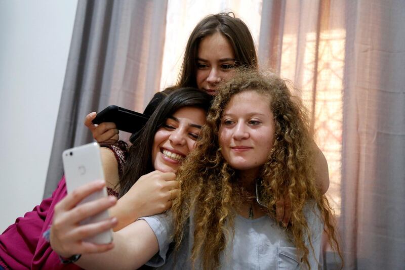 Palestinian teenager Ahed Tamimi, who was released from an Israeli prison on Sunday, takes a selfie with her friends at her family's house in Nabi Saleh village in the occupied West Bank July 30, 2018. REUTERS/Raneen Sawafta      TPX IMAGES OF THE DAY