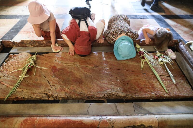 Christian pilgrims touch the Stone of Anointing and pray during the Palm Sunday procession at the Church of the Holy Sepulchre in Jerusalem. About 300 million Orthodox Christians around the world observe Holy Week. EPA