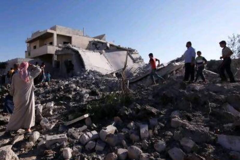 Residents inspect the damage after an air raid by Syrian government forces north of Aleppo yesterday. The Syrian leadership is suspected of having stocks of nerve and mustard gas, and Scud missiles with which to deliver them.