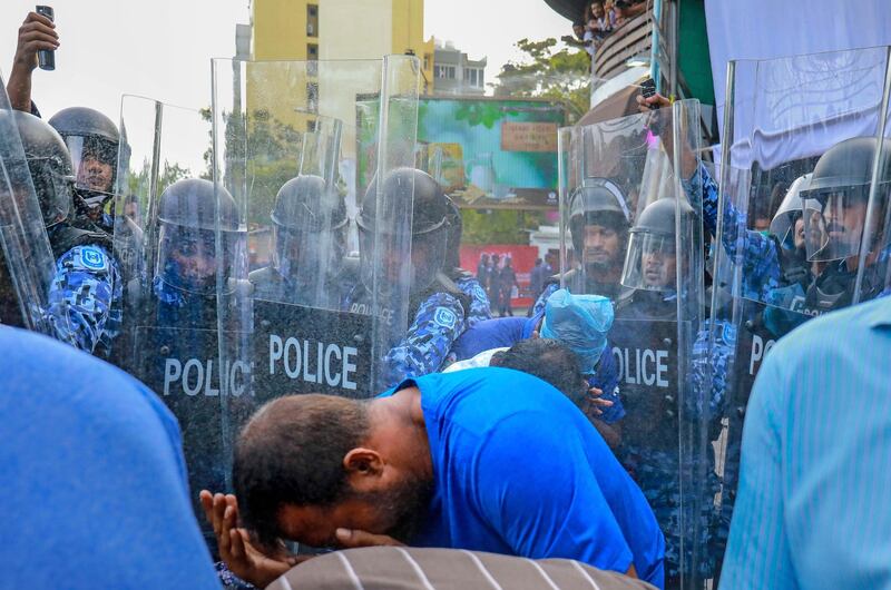 In this photo taken Friday, Feb. 16, 2018, policemen use pepper spray to disperse pro-opposition supporters during a protest in Male, Maldives. Dozens of pro-opposition supporters have been injured and many were arrested after police in the Maldives broke up countrywide protests demanding the resignation of President Yameen Abdul Gayoom and the release of his political opponents from prison. (AP Photo/Mohamed Sharuhan)