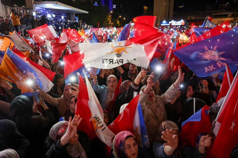 Mr Erdogan's supporters wave flags outside the AK Party's headquarters in Ankara. Reuters