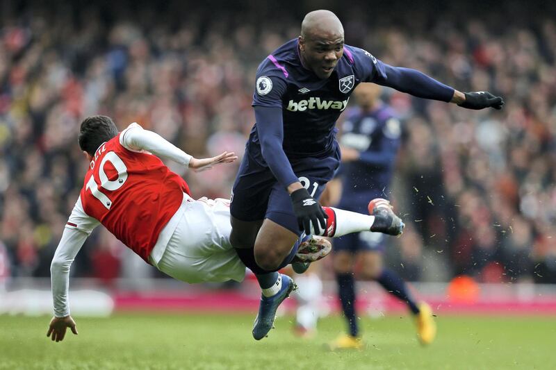 Arsenal's German midfielder Mesut Ozil (L) vies with West Ham United's Italian defender Angelo Ogbonna (R) during the English Premier League football match between Arsenal and West Ham at the Emirates Stadium in London on March 7, 2020. (Photo by Ian KINGTON / AFP) / RESTRICTED TO EDITORIAL USE. No use with unauthorized audio, video, data, fixture lists, club/league logos or 'live' services. Online in-match use limited to 120 images. An additional 40 images may be used in extra time. No video emulation. Social media in-match use limited to 120 images. An additional 40 images may be used in extra time. No use in betting publications, games or single club/league/player publications. / 