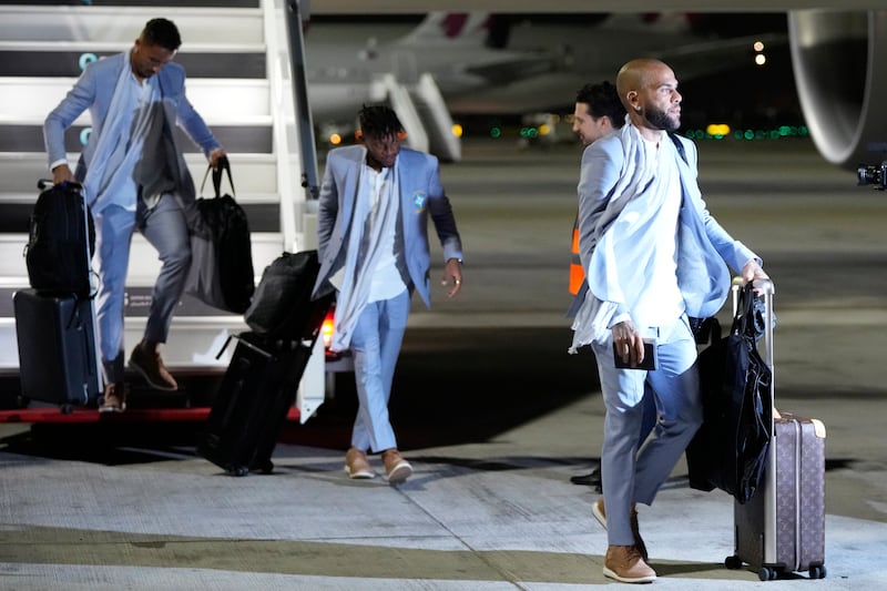 Dani Alves, right, arrives with teammates at Hamad International Airport. AP
