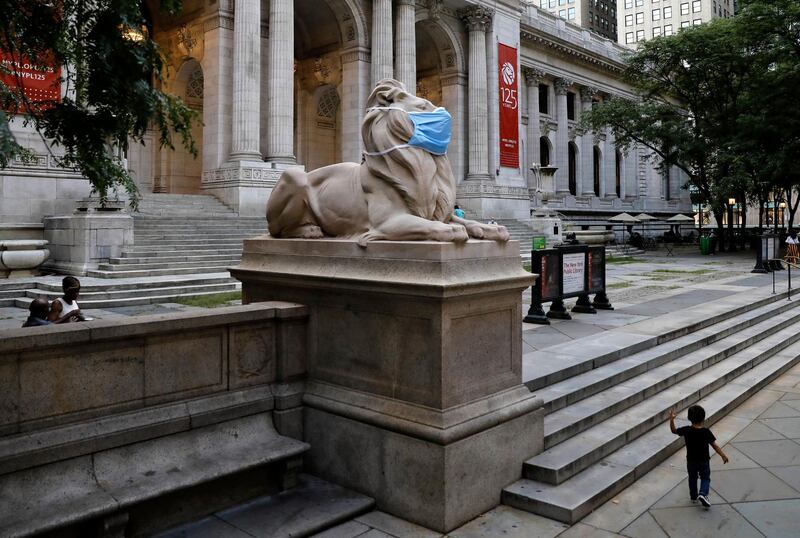 The lion statue in front of the 42nd street New York Public Library adorns a protective mask to remind the public to wear masks. EPA