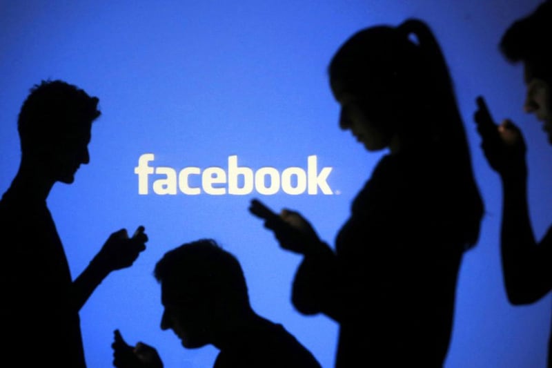 People are silhouetted as they pose with laptops in front of a screen projected with a Facebook logo, in Zenica. Facebook warned on Tuesday of a dramatic increase in spending in 2015 and projected a slowdown in revenue growth this quarter, slicing a tenth off its market value. Facebook shares fell 7.7 per cent in premarket trading the day after the social network announced an increase in spending in 2015 and projected a slowdown in revenue growth this quarter.  Dado Ruvic / Reuters
