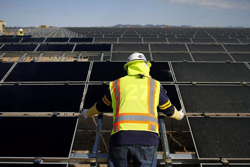 A worker installs photovoltaic solar panels at the Agua Caliente solar project in Yuma County, Arizona in 2012. The same panels will be installed at the Mohammed bin Rashid Al Maktoum solar park in Dubai. Joshua Lott / Bloomberg News
